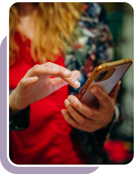 снимка на Петрана с червени дрехи, която държи в ръцете си смартфон